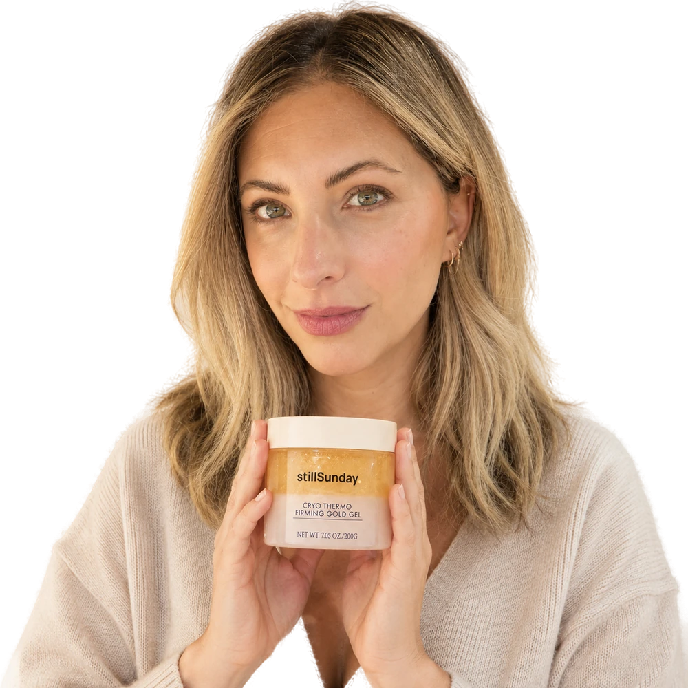 Woman holding the stillSunday Cryo-Thermo Firming Gold Gel jar in a quiet morning moment.
